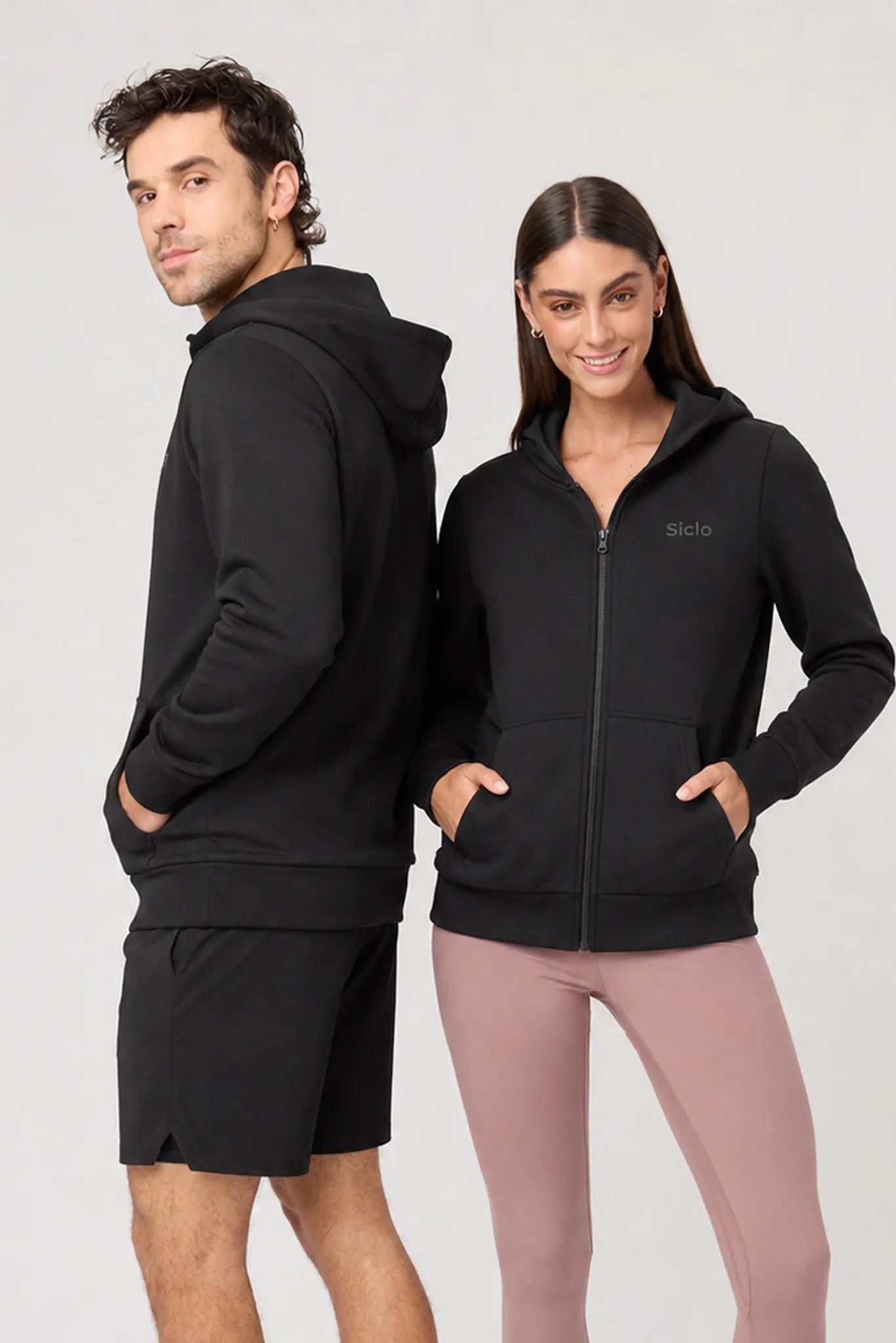 Chamarra deportiva unisex Transit negra vista frontal en pareja