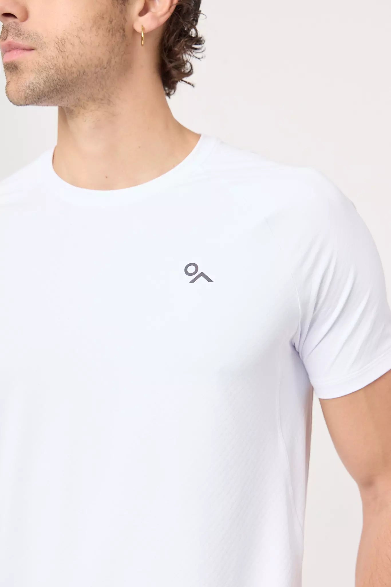Detalle frontal y logo de la playera deportiva Apex Tee blanca