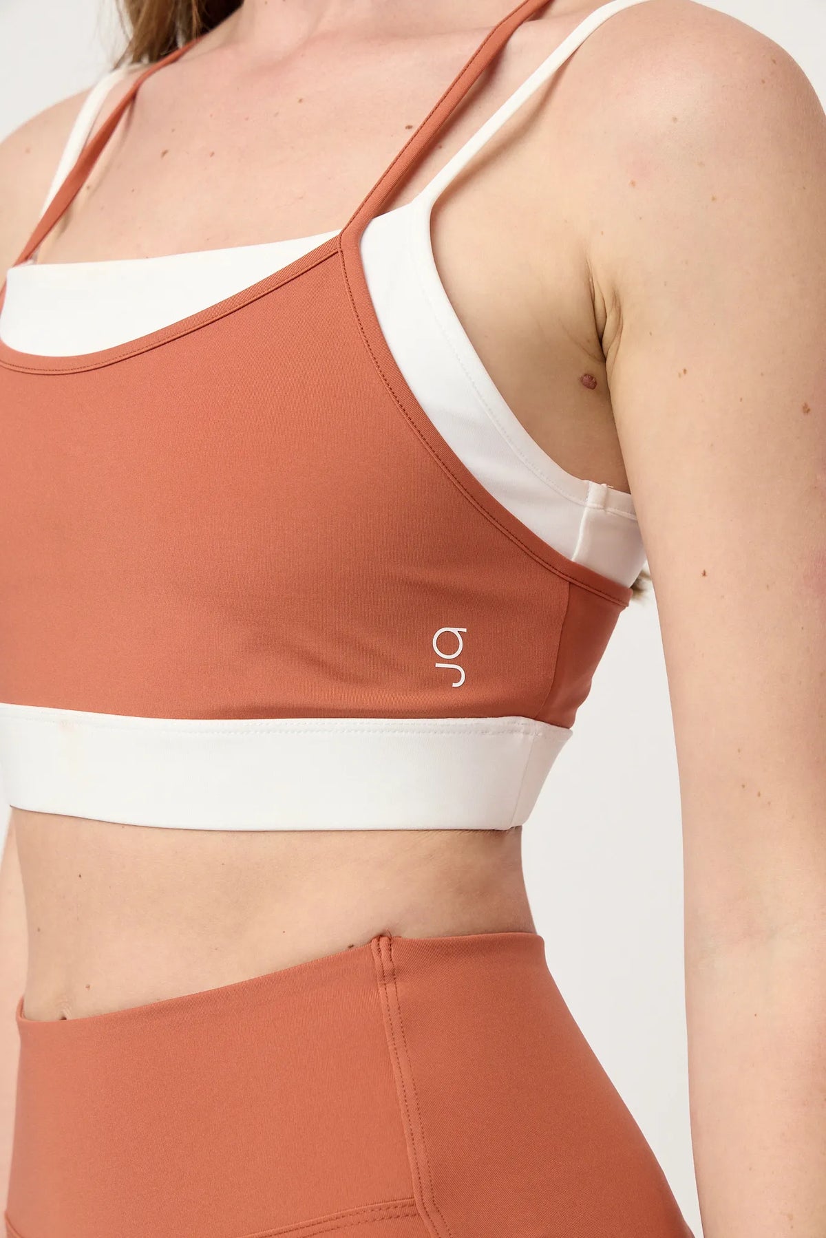 Detalle lateral y ajuste del top deportivo Core Terracota